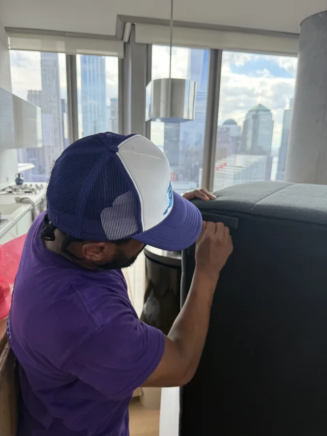 Mover handling a large furniture piece inside an apartment
