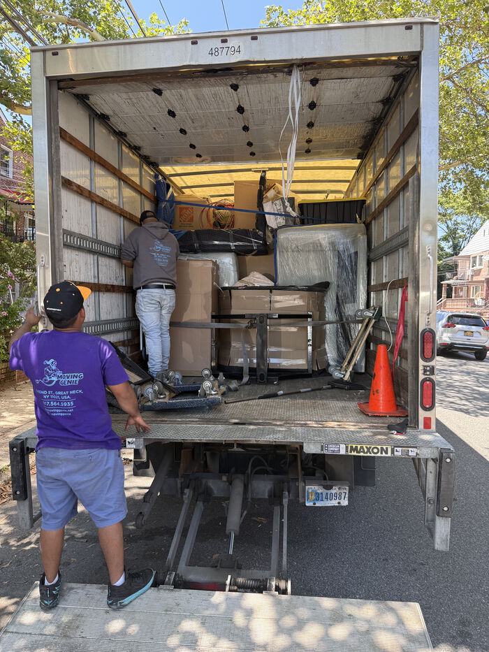 Movers loading a moving truck on a Queens residential street