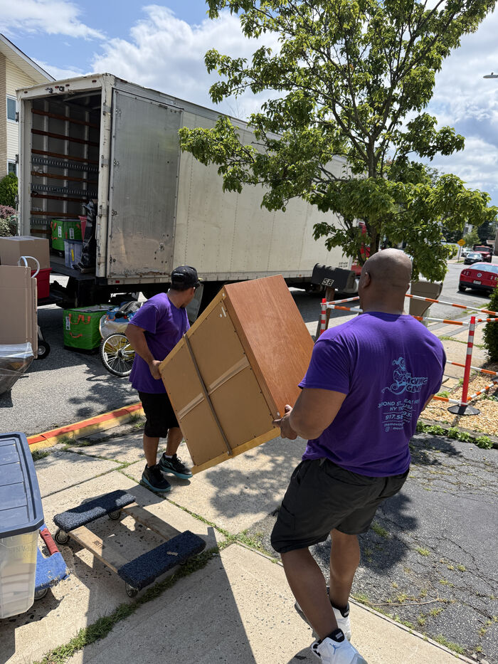 Moving crew unloading a trailer at a suburban single-family home in Bayside, Queens