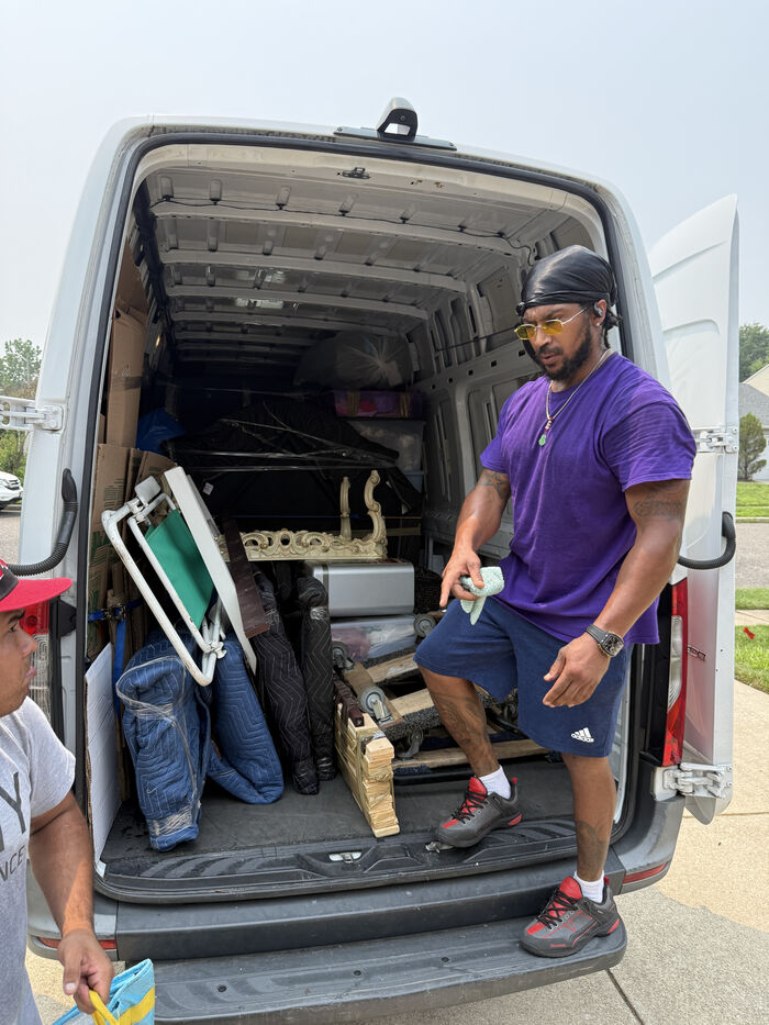Interior of a moving truck packed by professionals with heavy furniture against the front wall and boxes stacked by weight